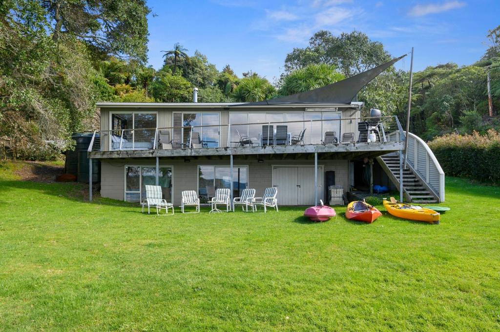 a house with a deck and four boats on the yard at Onepoto Bay Lakehouse - Lake Rotoiti Holiday Home in Okere Falls