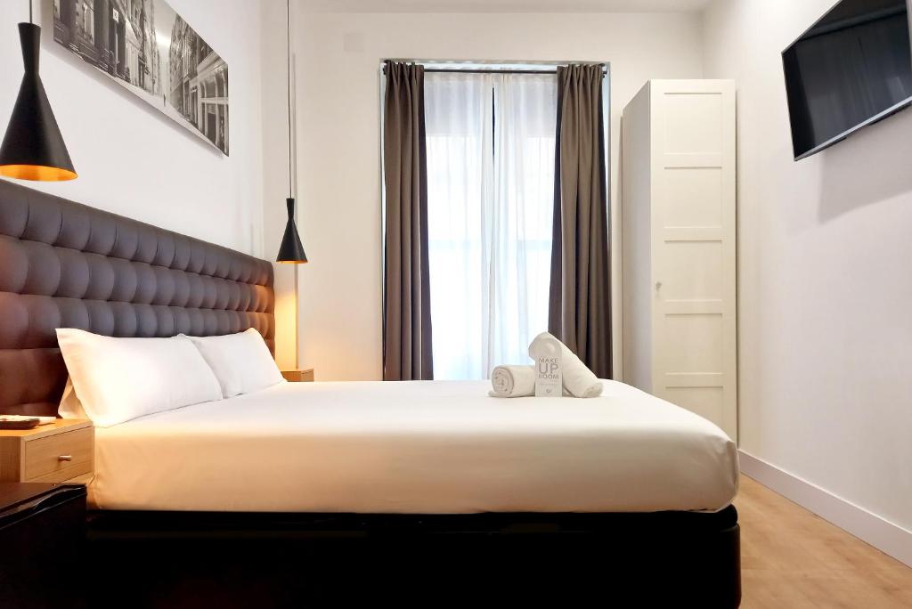 Un dormitorio con una cama grande y una ventana en Woohoo Rooms Chueca, en Madrid