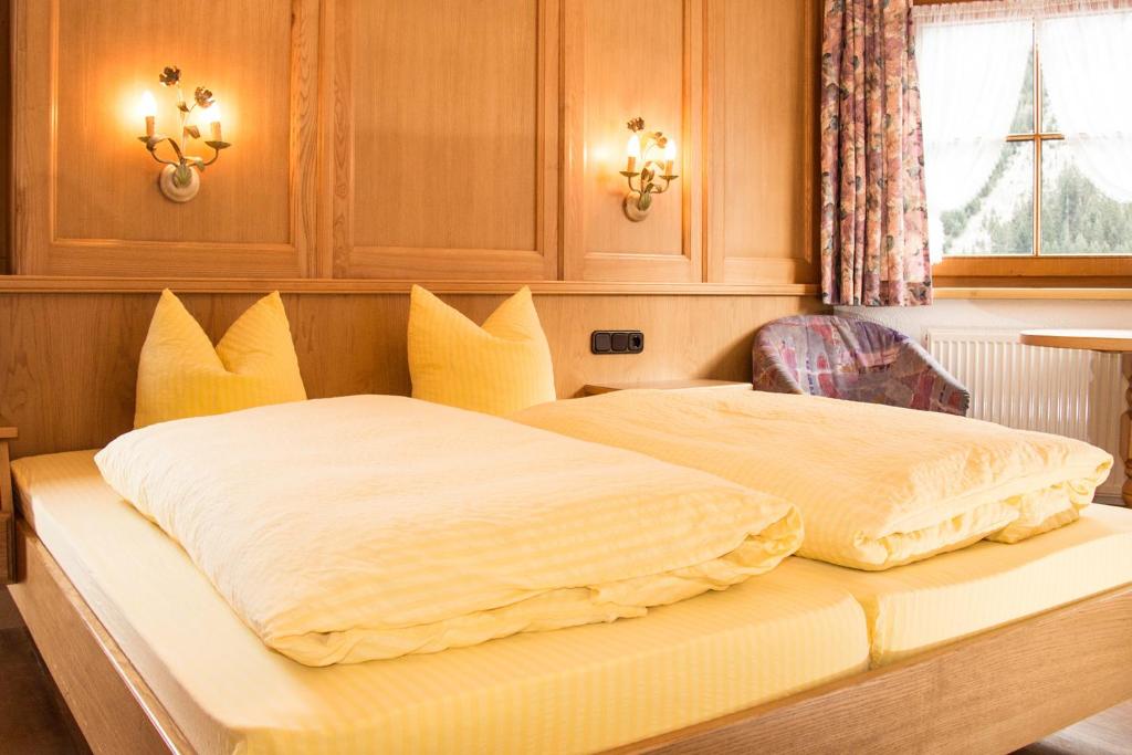 sypialnia z dwoma łóżkami i żółtymi poduszkami w obiekcie Appartement Paulis Hof w mieście Ischgl