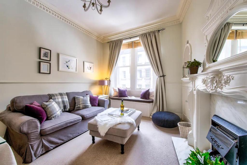 a living room with a couch and a fireplace at ALTIDO Lovely 1 bed flat in Old town, right on the Royal Mile in Edinburgh
