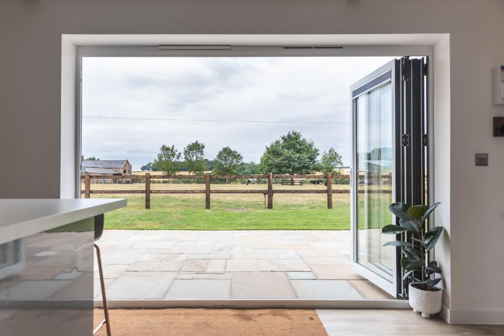 an open door to a patio with a view of a field at Apartment in the Countryside with Hot Tub in Trowbridge