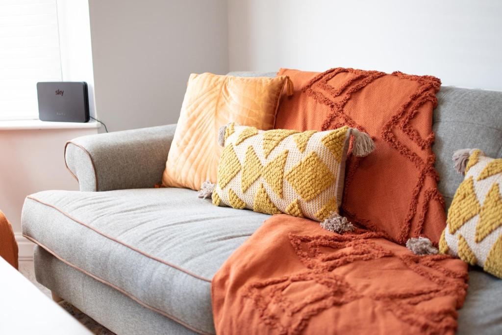 a couch with pillows on it in a living room at Ideal Lodgings in Royton in Royton