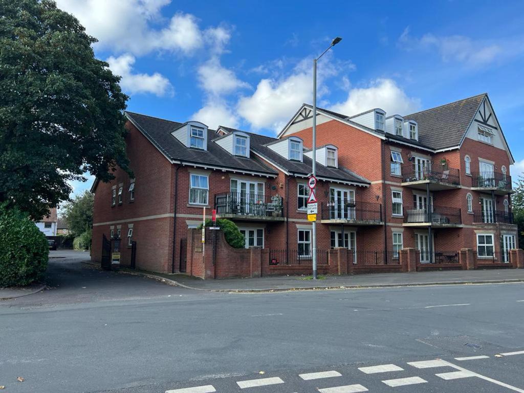 a large red brick building on the corner of a street at Beautiful 2-Bed Apartment in Poulton-le-Fylde in Poulton le Fylde