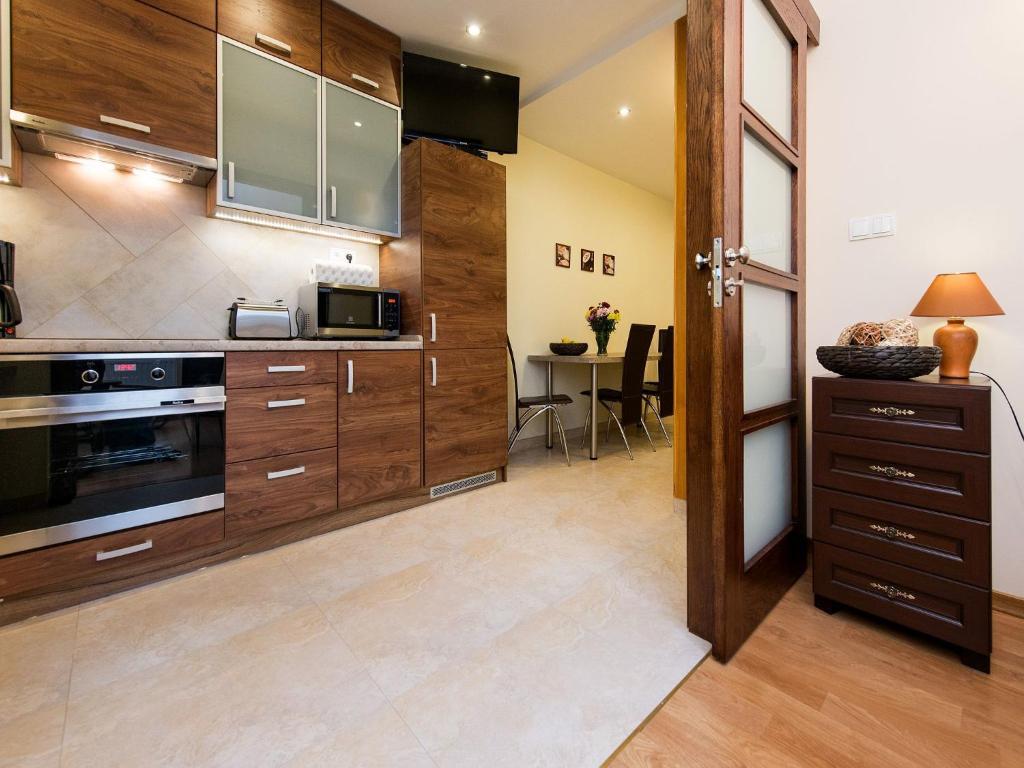 cocina con armarios de madera y mesa en Vanilla Apartment 1, en Cracovia