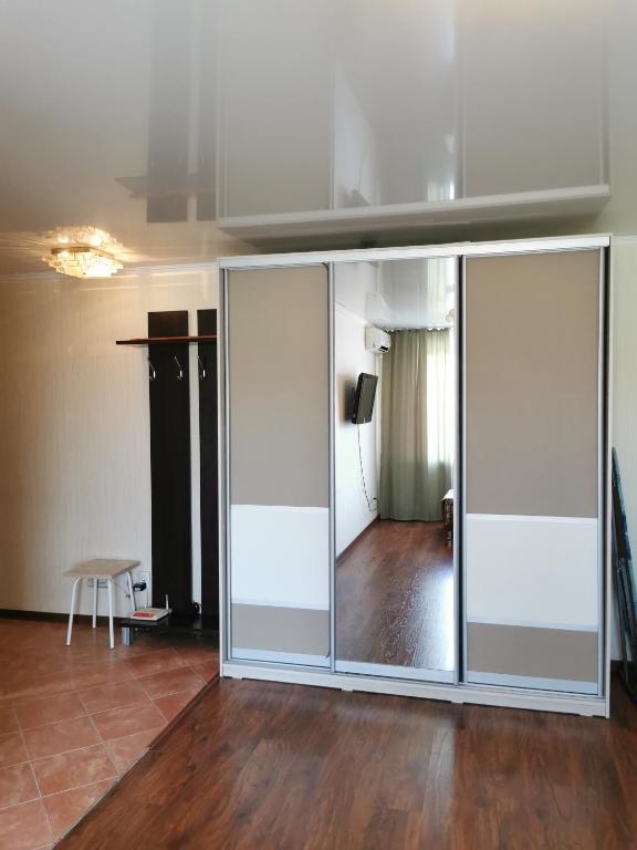 uma grande parede de vidro num quarto com piso de madeira em 1 комн квартира в центре em Qostanay