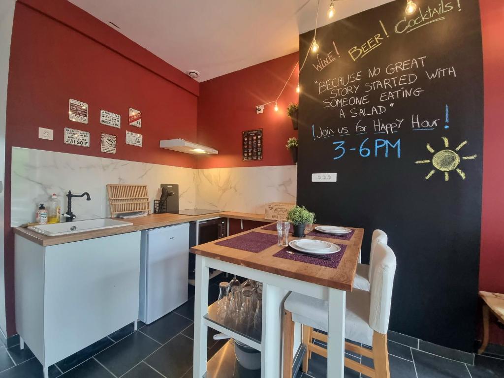 a kitchen with red walls and a table and a sink at La Trappiste in Liévin