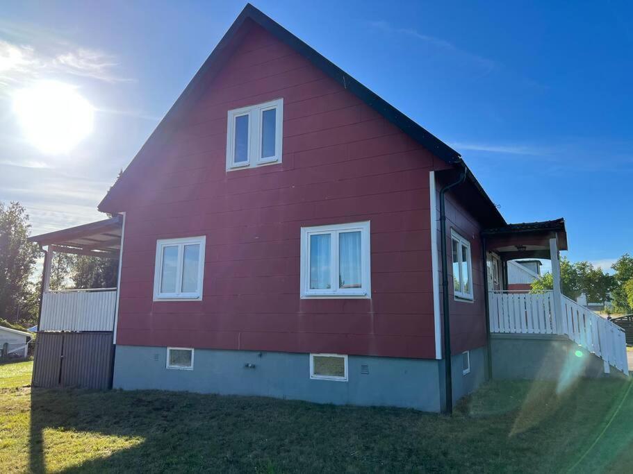 una casa roja con ventanas blancas en un patio en Big house, sauna, Wi-Fi, Isaberg, MTB, skiing, golf en Gnosjö