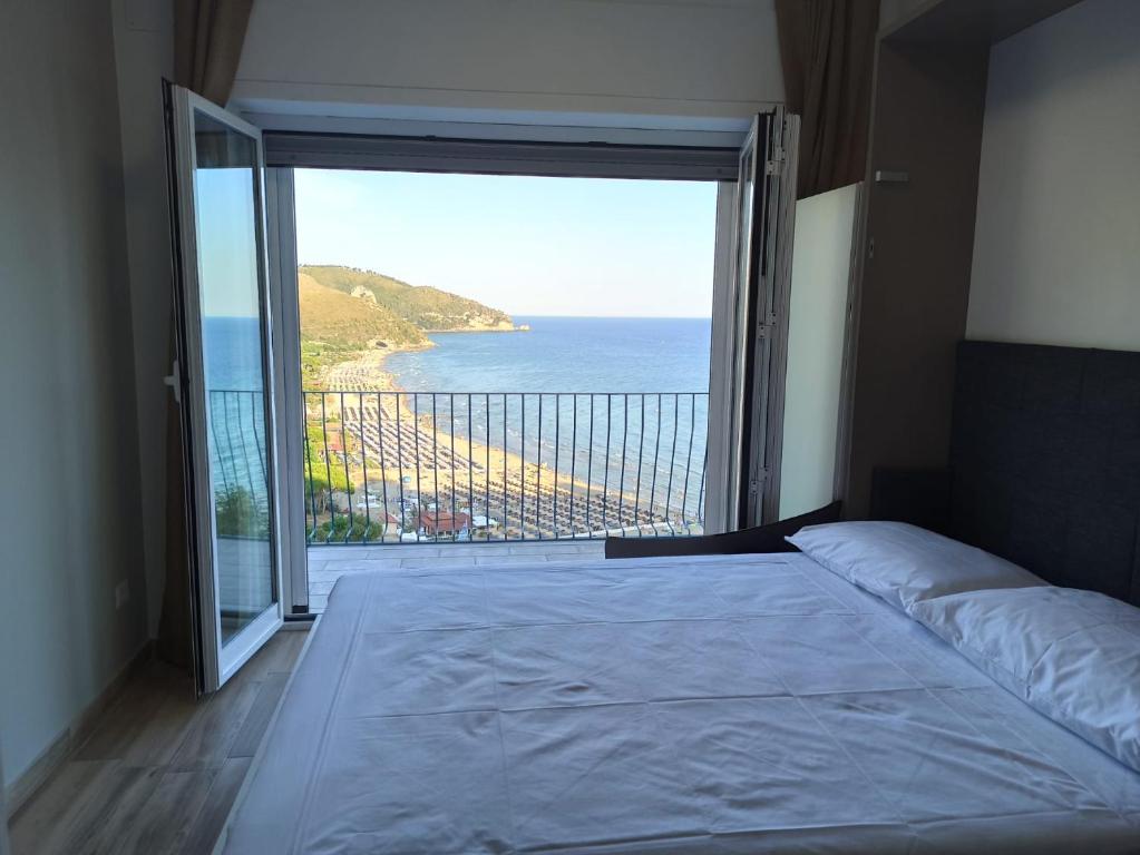 una camera da letto con una grande finestra con vista sull'oceano di Cristalli di mare room a Sperlonga