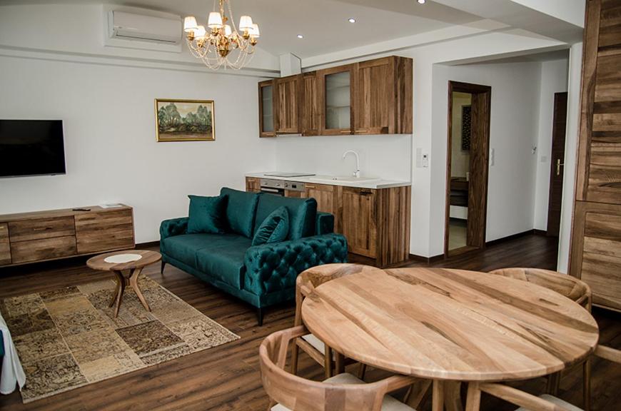 salon z zieloną kanapą i stołem w obiekcie Edemus - Motel & Restaurant w mieście Maglaj