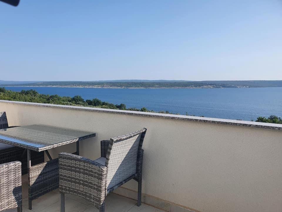 een tafel en stoelen op een balkon met uitzicht op het water bij Modern Seeview Apartment Maslenica with Free WIFI and Free PARKING in Maslenica