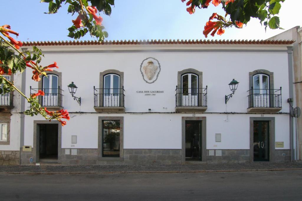 Un edificio bianco con una statua sul lato. di Casa dos Lacerdas a Mourão