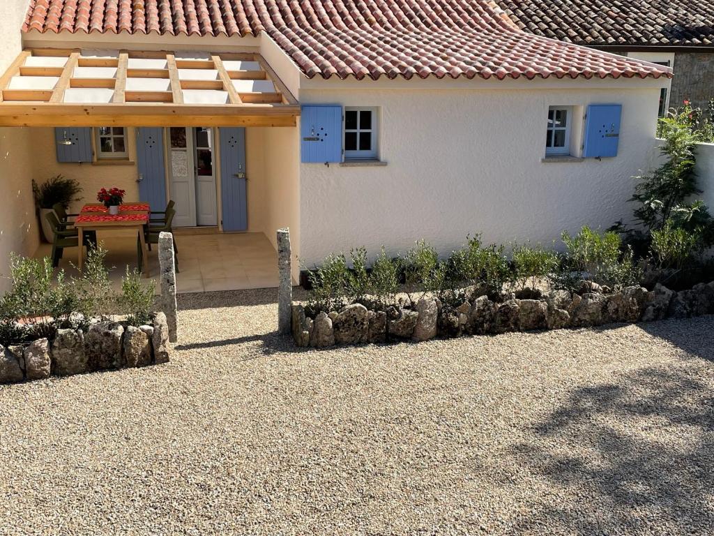 a house with a patio and a table in front of it at STAZZU LU CHISSONI in Luogosanto