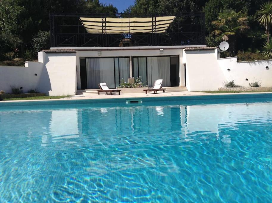 basen z dwoma krzesłami obok domu w obiekcie Rome villa swimming pool w mieście Campagnano di Roma