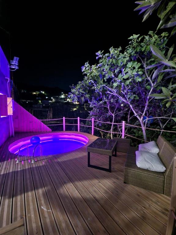 a swimming pool is lit up at night at Aprosmeno Jacuzzi House 3 With Private Pool in Agros