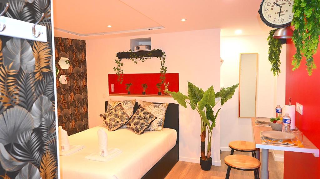 uma sala de estar com um sofá e um relógio na parede em SAUNA Appartement 10mn Aeroport Roissy CDG em Villeneuve-sous-Dammartin