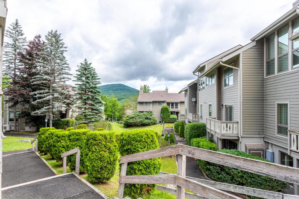 a house with a wooden bridge in front of a yard at Mountainside Haven - walk to Hunter Mtn! in Hunter