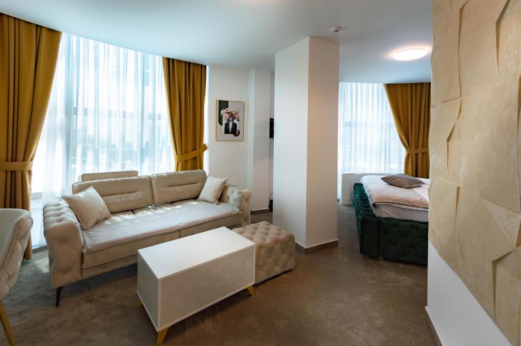 un soggiorno con divano e letto di Hotel IDEAL Deluxe a Novi Pazar