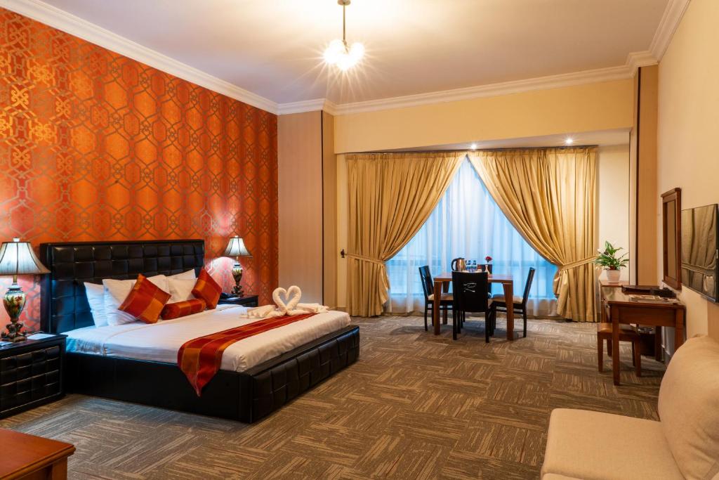 a hotel room with a bed and a dining room at Grand Safir Hotel in Manama