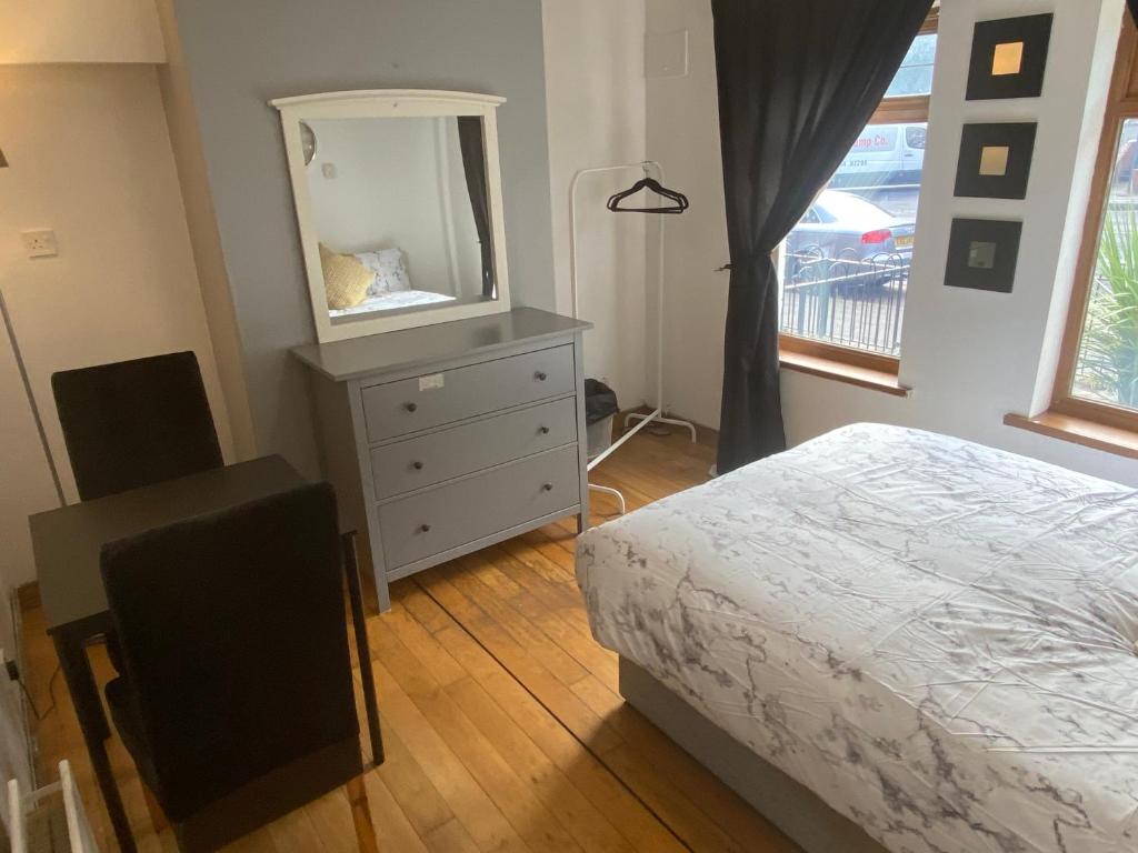 a bedroom with a bed and a dresser with a mirror at bnb81 in Belfast
