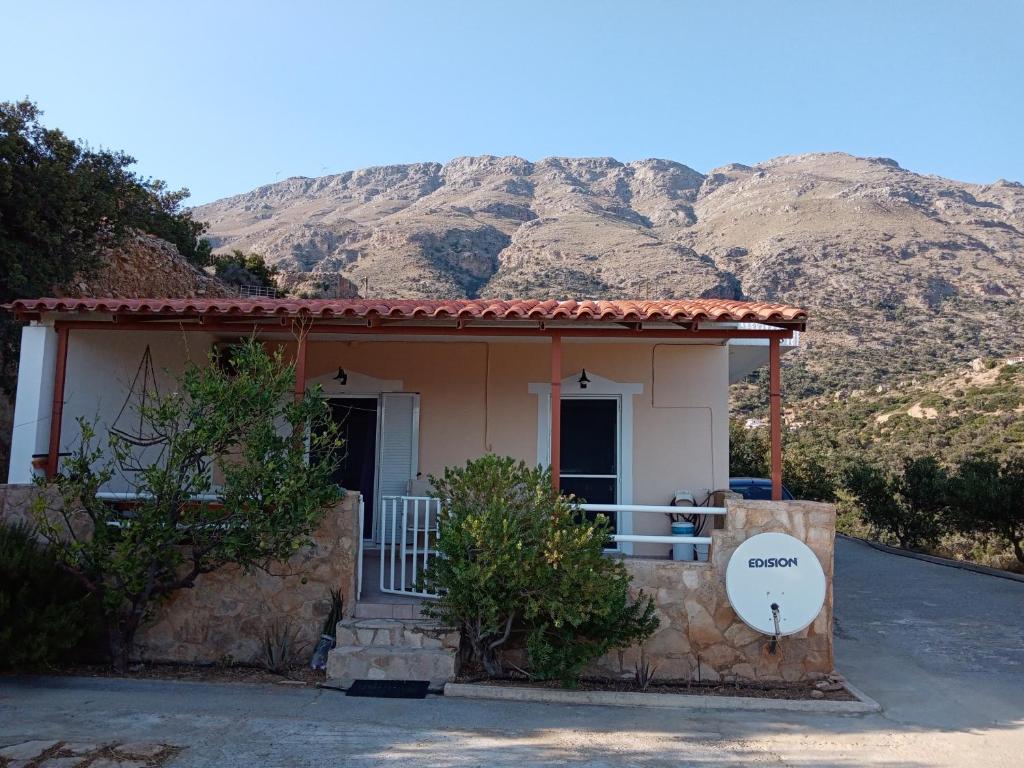 een klein huis met een berg op de achtergrond bij Triopetra hill view in Triopetra