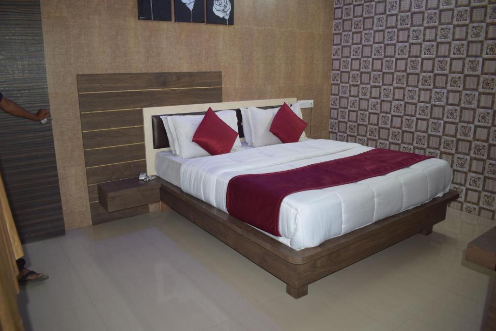 um quarto com uma cama grande e almofadas vermelhas em The Sky Comfort - Hotel The Heaven, Dwarka em Dwarka