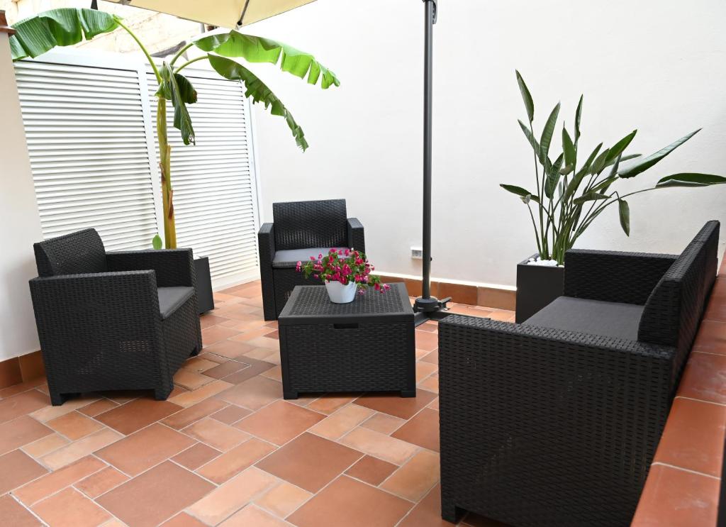 um pátio com cadeiras, mesas e plantas em Haven of Civita em Fondi