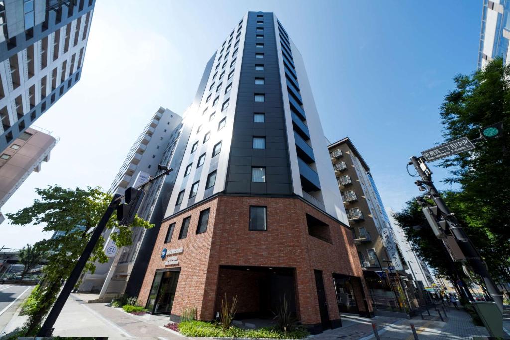 a tall brick building on a city street at Best Western Hotel Fino Shin-Yokohama in Yokohama