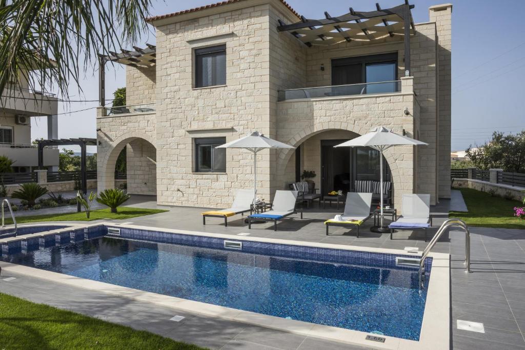 a villa with a swimming pool and a house at Villa-Azalea in Almyrida