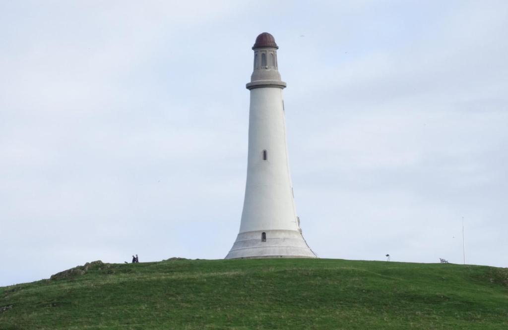 a lighthouse sitting on top of a grassy hill at 3 bedroom apartment in Ulverston Cumbria in Ulverston