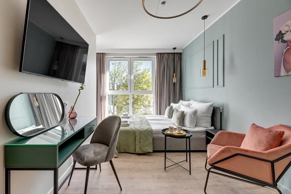 a bedroom with a bed and a desk and a mirror at Downtown Apartments City Center Aura 40 in Gdańsk
