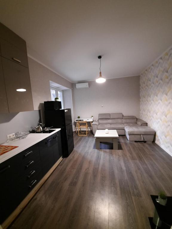 a living room with a couch and a table at Futuristic 1 Bedroom Apartment next to Vake Park in Tbilisi City