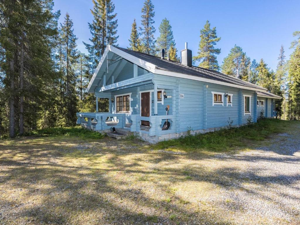 a blue house in the middle of a forest at Holiday Home Uolevintie 39a by Interhome in Ruka