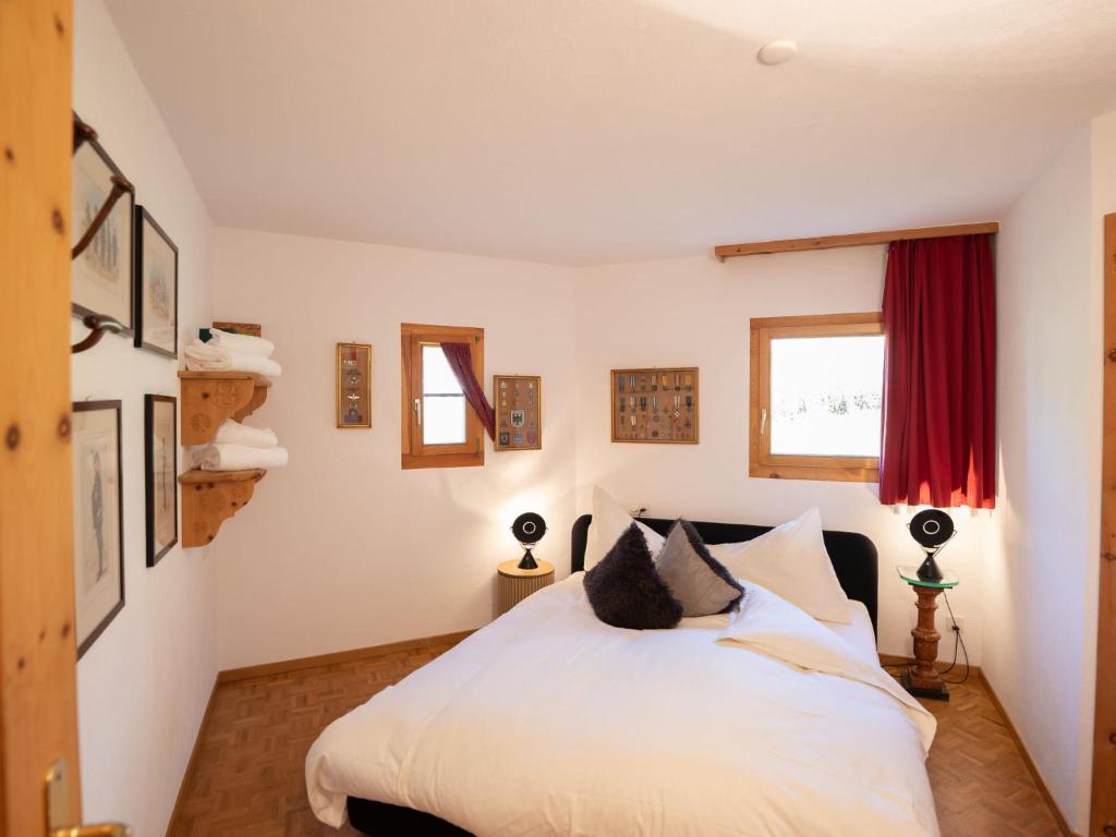 um quarto com uma cama branca e uma janela vermelha em Apartment Chesa Cresta by Interhome em Surlej