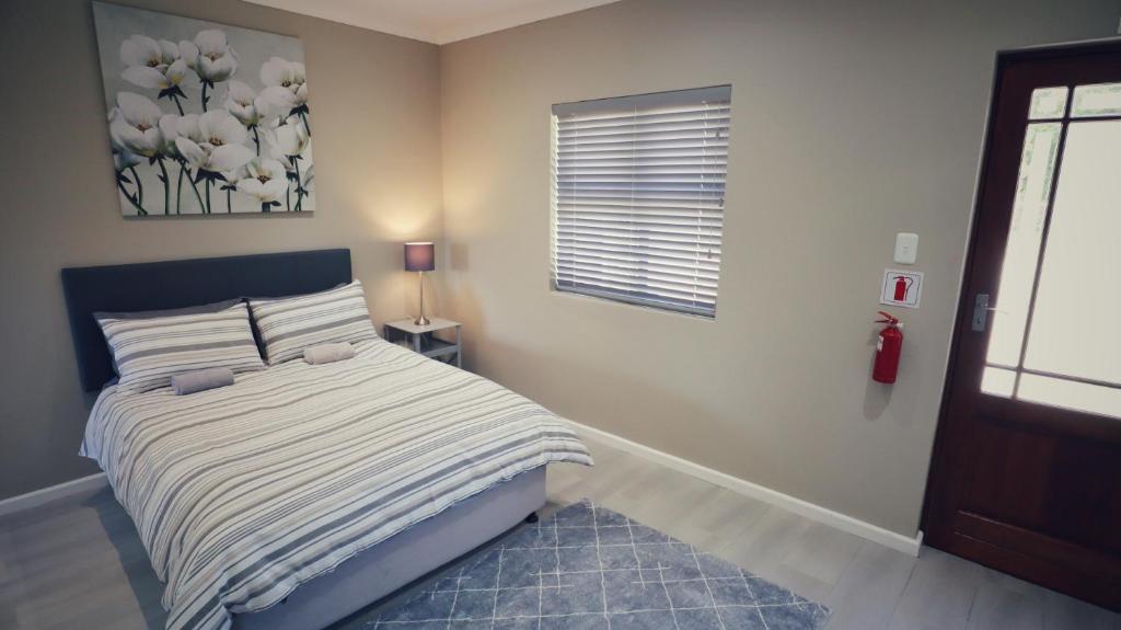a bedroom with a bed and a window at Guest Suite, Lorraine Port Elizabeth in Lorraine