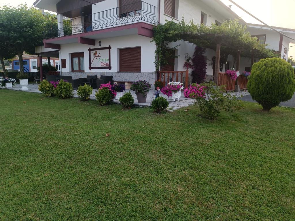 a house with a bunch of plants in the yard at Atxispe Etxea Casa Rural in Laukiz