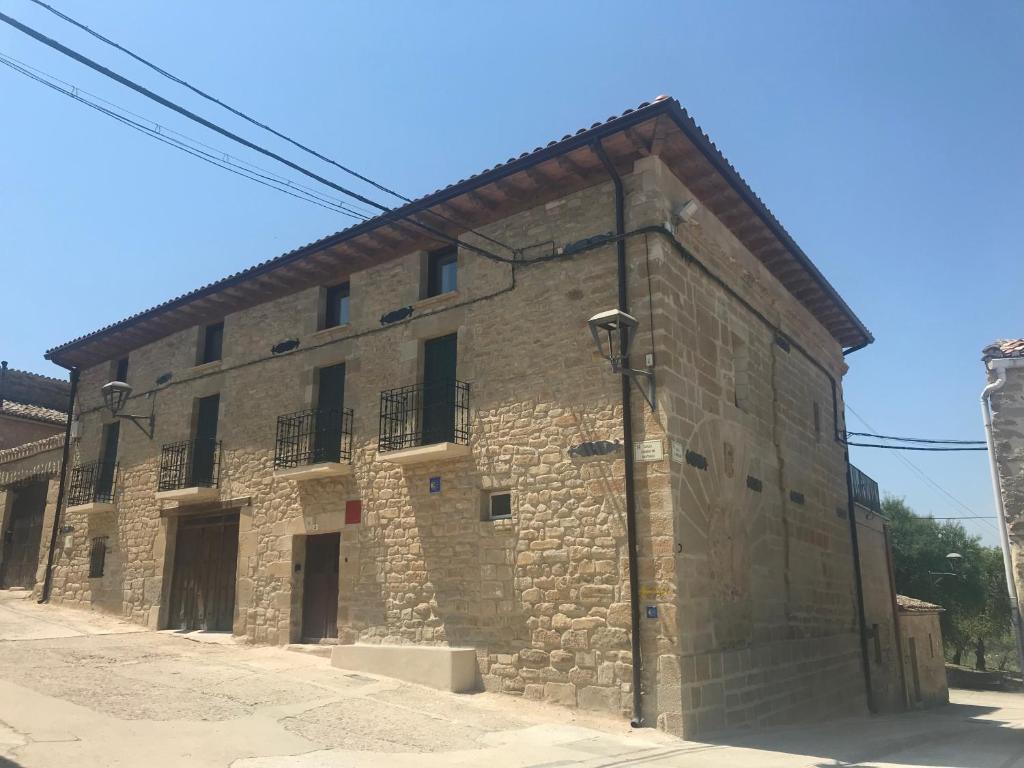 - un grand bâtiment en pierre avec des fenêtres sur le côté dans l'établissement CASA EGIPCIA Preciosa casa centenaria en el Camino de Santiago, à Torres del Río