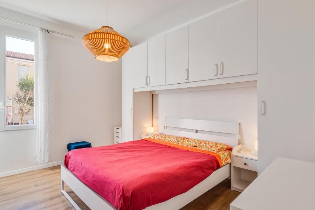 a bedroom with a red bed in a white room at Corte Agordat Apartment x4 - Pet Friendly in Padova
