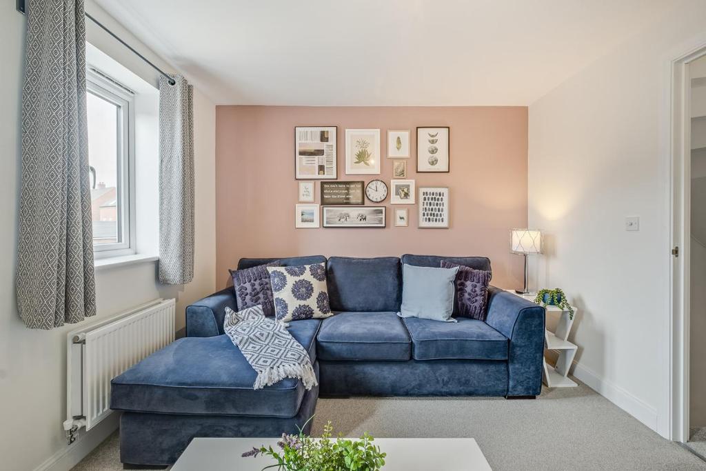 a living room with a blue couch and a chair at Stunning Family Friendly Home - Free Parking in Bedford