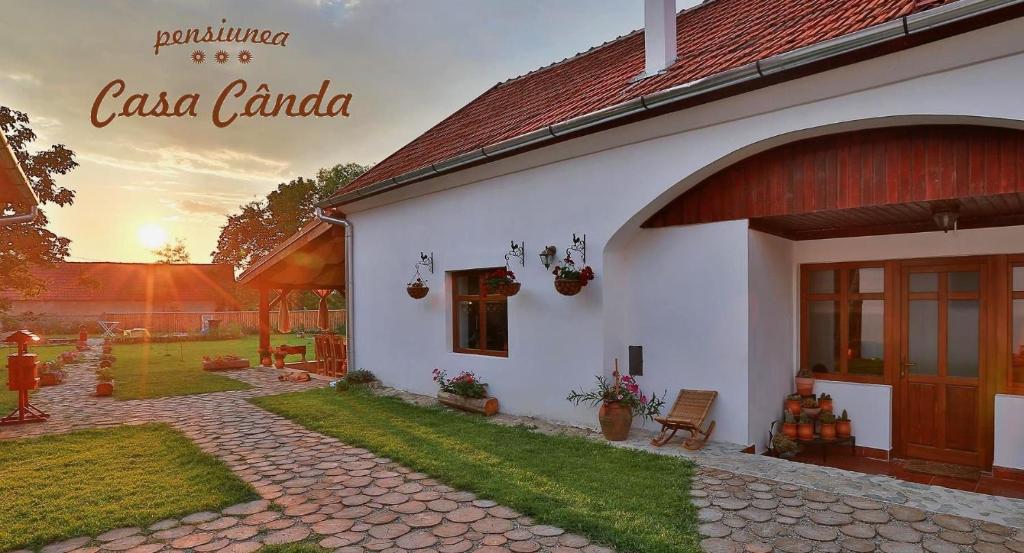 a white house with a patio and a yard at Casa Cânda in Sălaşu de Sus