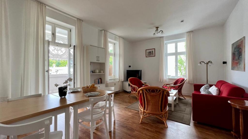 cocina y sala de estar con mesa y sillas en Villa Sonneck – Wohnung 15 en Ostseebad Sellin