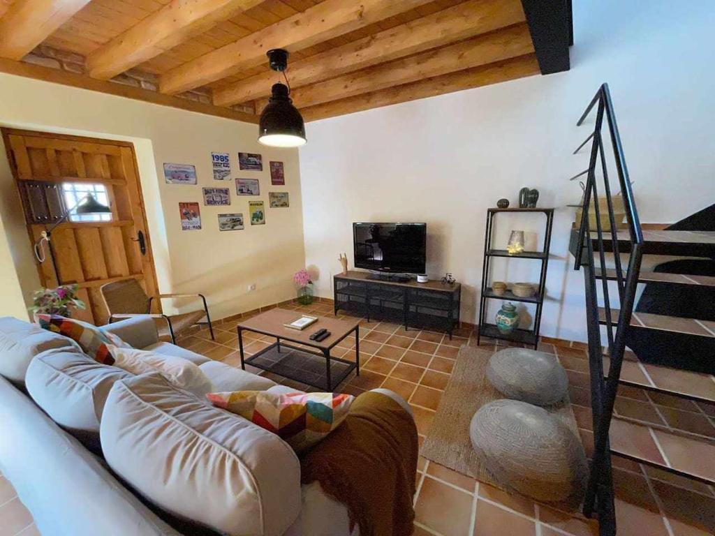 a living room with a couch and a tv at Encuentra el norte en la "Casa del buen camino" in Oreña