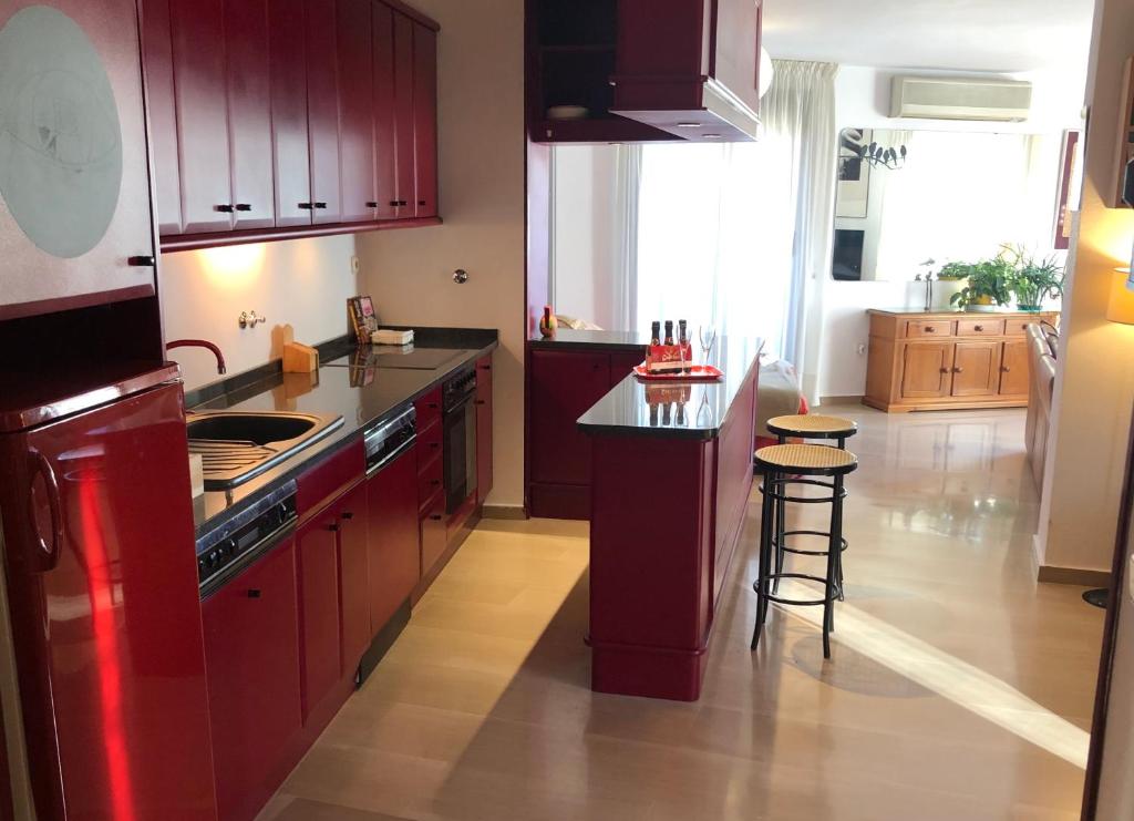 a kitchen with red cabinets and a stove top oven at Loft acogedor con terraza y parking en el centro in Huesca