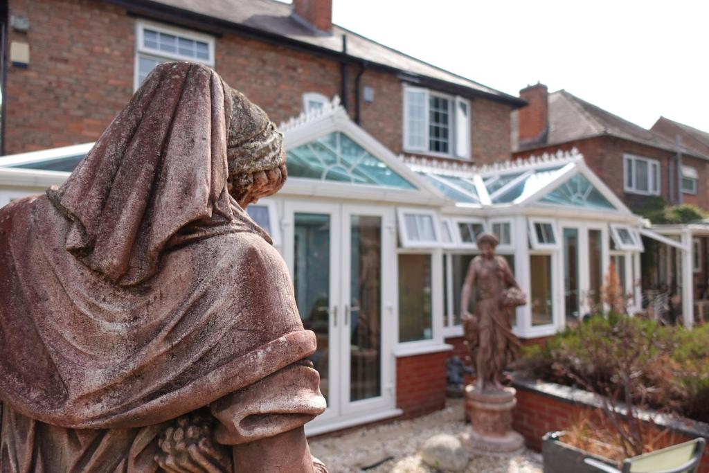 una estatua de una mujer frente a una casa en Largee 5 Bed House, Sleeps 10 Near NEC, BHX, HS2, en Birmingham