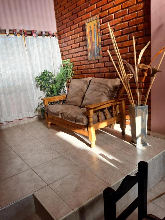 a couch sitting on a patio with a brick wall at KARMEL "tu lugar' in Maipú
