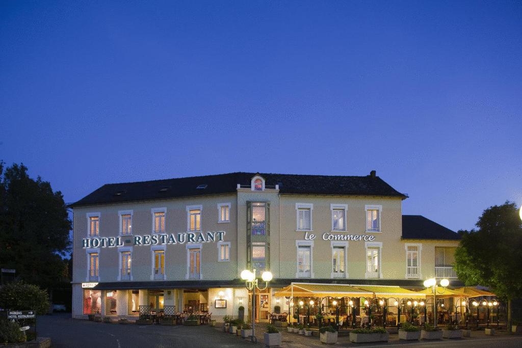 un grand bâtiment avec un hôtel en face dans l'établissement Logis Hôtel-Restaurant Le Commerce, à Rieupeyroux