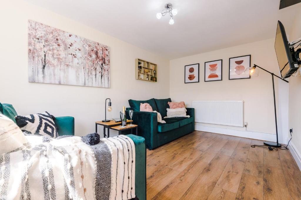 a living room with a green couch and a chair at Charming 3-Bed cottage in Chester, ideal for Families & Workers, FREE Parking - Sleeps 7 in Chester