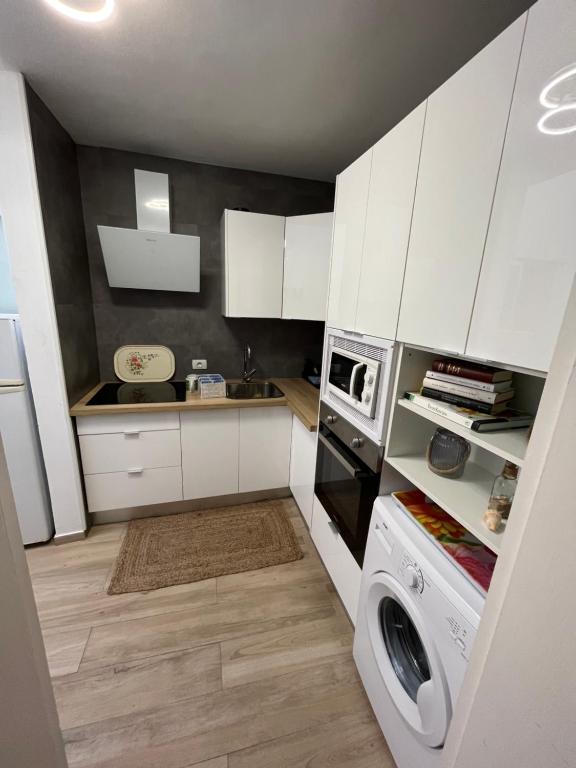 eine Küche mit weißen Schränken und einer Waschmaschine in der Unterkunft CORNELIA´S HOME 1A playa in Los Cristianos