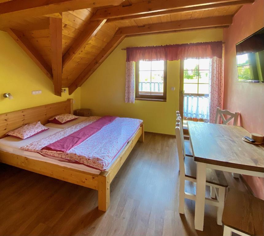 a bedroom with a bed and a dining room table at Penzion Major in Rokytnice nad Jizerou