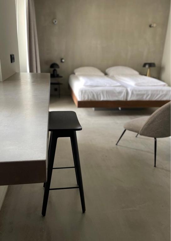 a room with a table and a bed and a chair at Hotel Mons am Goetheplatz in Munich