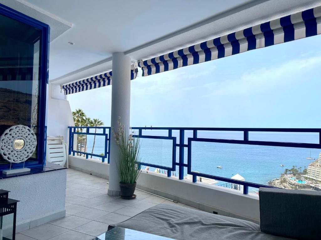 a room with a balcony with a view of the ocean at Apartment mit Traumblick in Taurito
